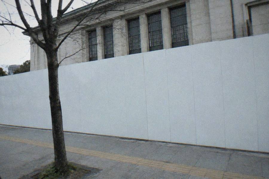 A bright contemporary art gallery with white walls and large framed artworks hanging in a row