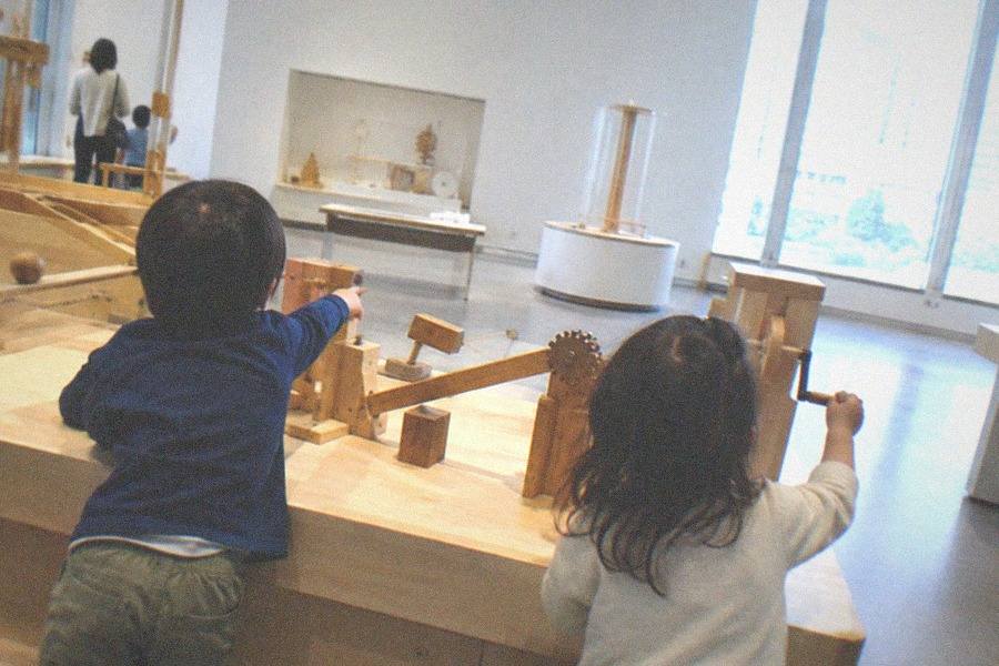 Wide view of a miniature city district with hundreds of tiny buildings under display lights