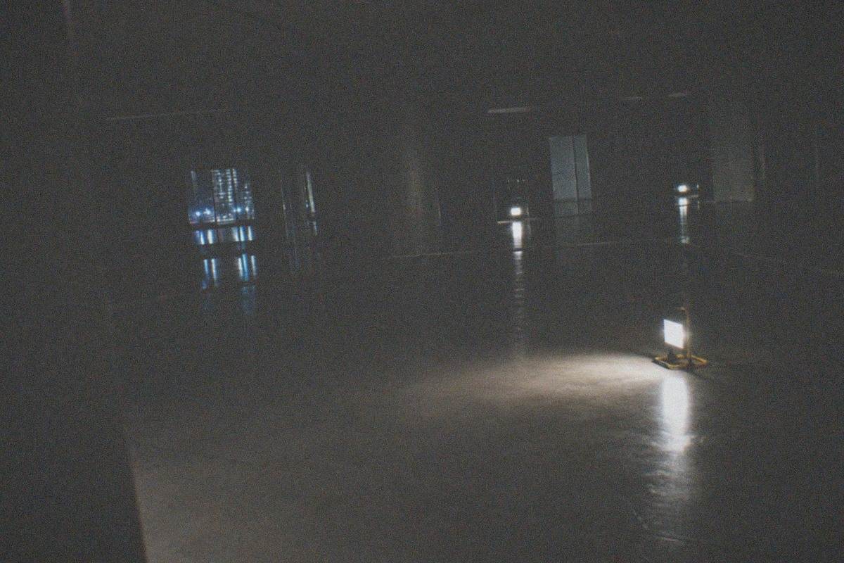 Dark gallery hall filled with glowing digital art projected across walls and floor