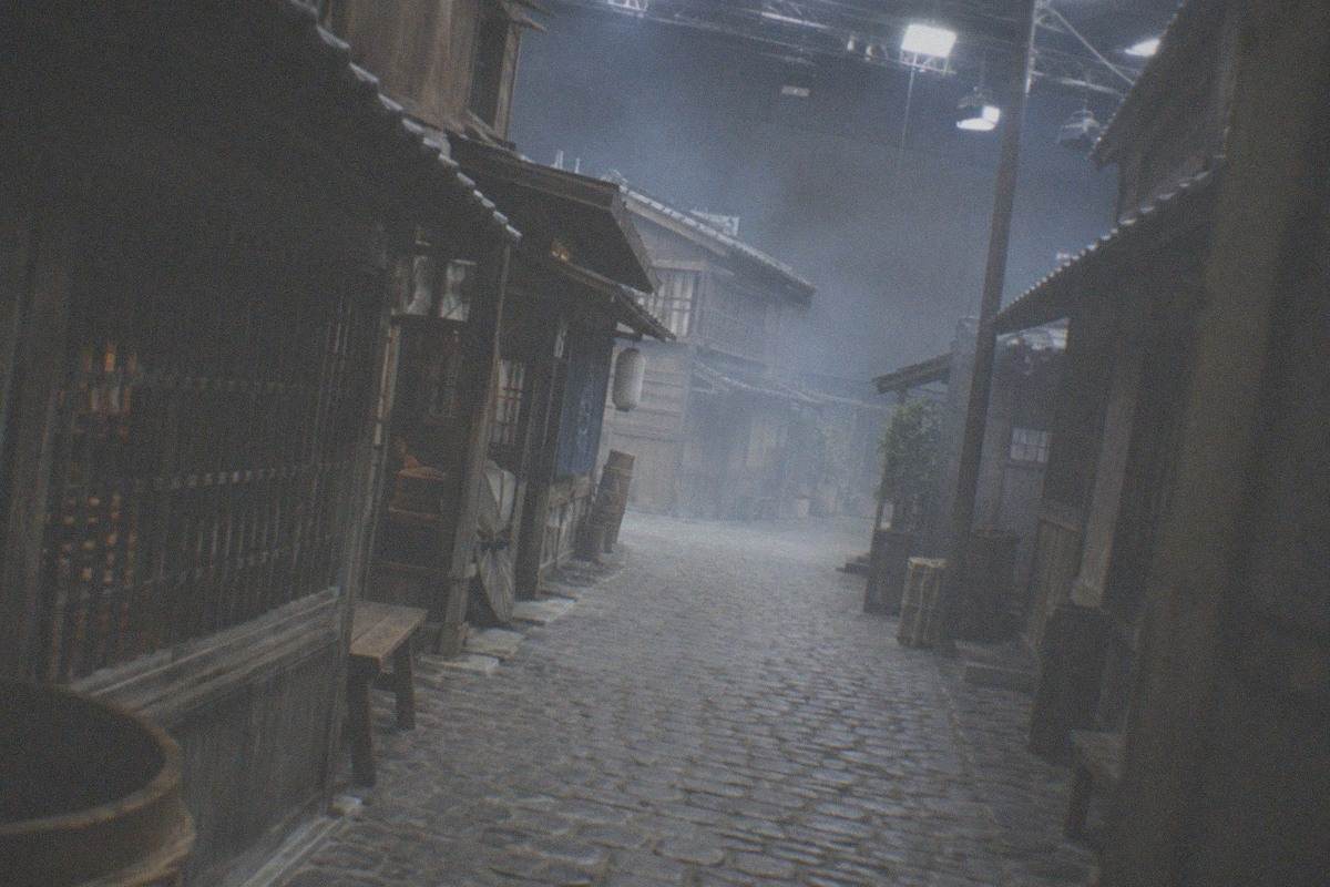 A studio backlot style street facade with period shopfronts under a soft sky