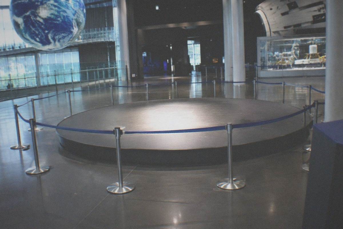 A large glowing globe display suspended in a dark exhibition hall of a science museum