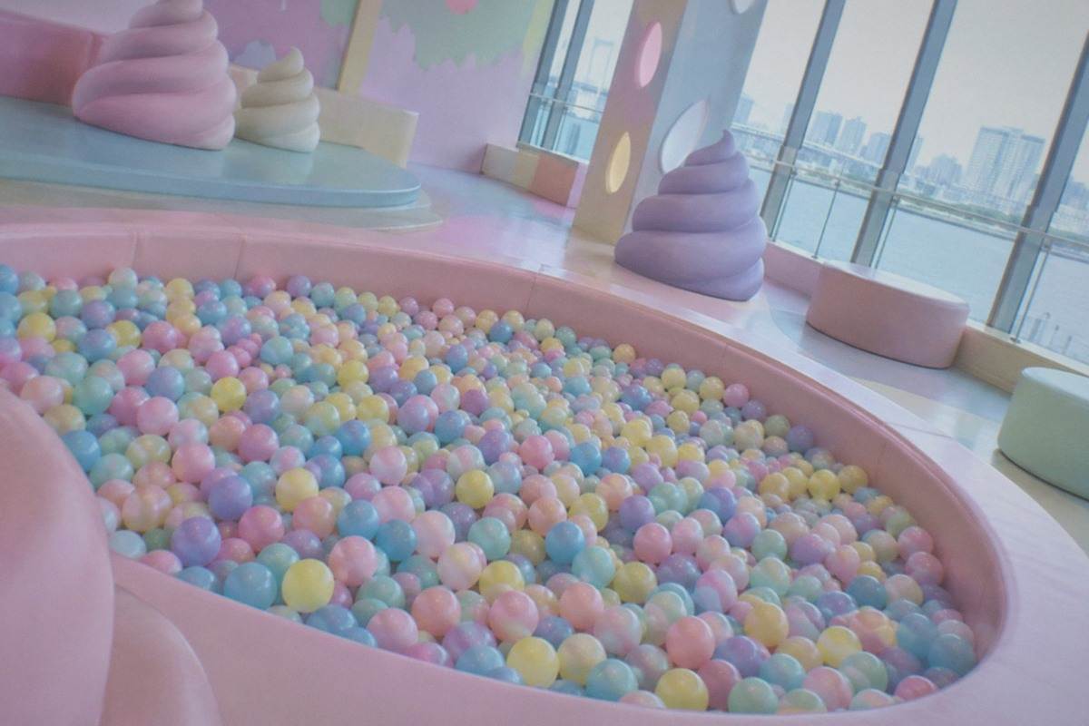 A bright colour-saturated exhibition room filled with playful sculptural displays inside a Tokyo museum