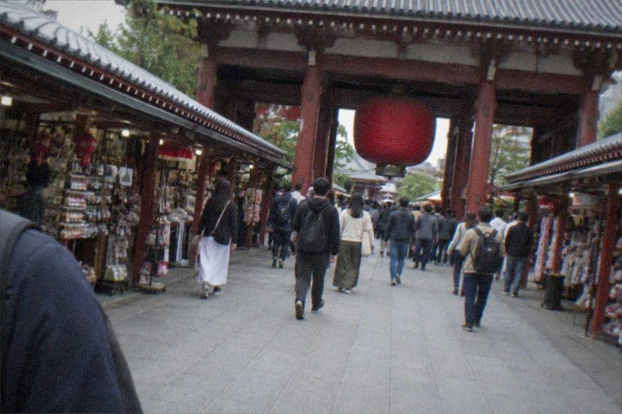 A visitor holding a phone showing a ticket booking screen outside a museum entrance
