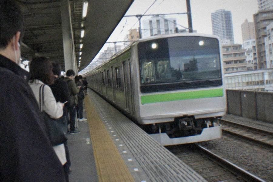 A train platform with a local line train waiting at a suburban station