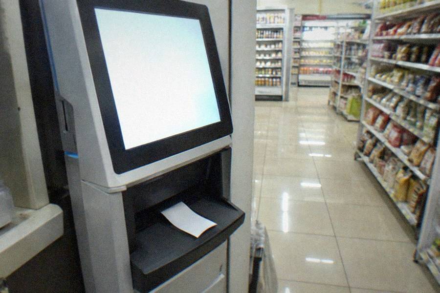 A museum lobby entrance with a digital ticket scanner and staff member checking phones