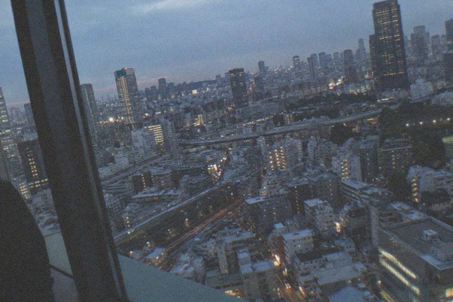 The Roppongi Hills Mori Tower entrance at dusk, with visitors heading toward the elevators to the upper floors