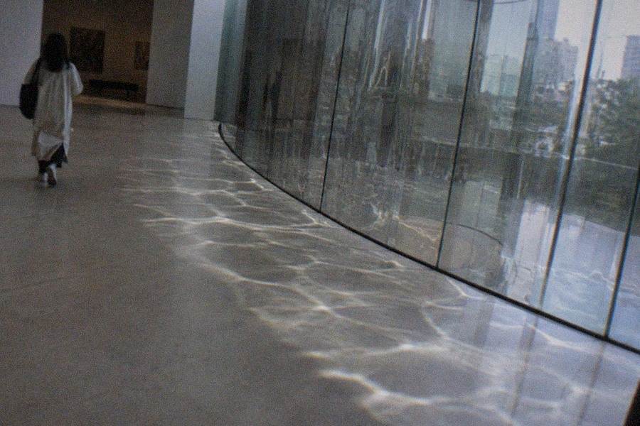The atrium of The National Art Center, Tokyo with the art library and restaurant floor visible across the open floor