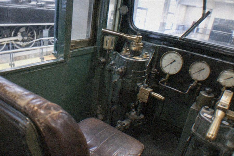 Visitors walking among the preserved locomotives and carriages inside The Railway Museum's main display hall in Omiya