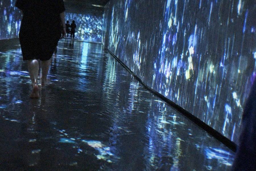 The mirrored corridor at teamLab Planets TOKYO stretching reflections of visitors into an apparently endless light-filled hall
